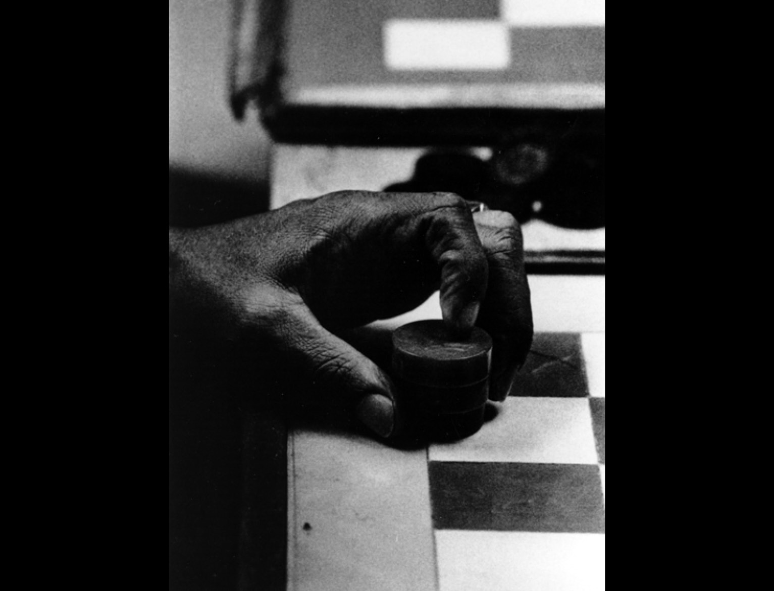 hand holding a game piece by a game board