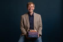 Robert Carpenter holding a stack of books